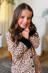Mom & Me - Fuzzy Cheetah Pajamas - CHILD-6-12 Months - Child wearing fuzzy cheetah-print pajamas with black cuffs and collar, smiling indoors.