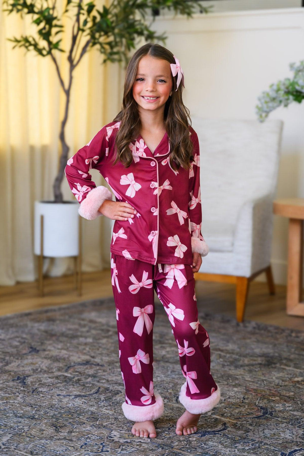 Mom & Me - Fuzzy Pink Bow Pajamas - CHILD-6-12 Months - Burgundy fuzzy pajamas with pink bow prints, button-up top and cuffed pants on young girl.