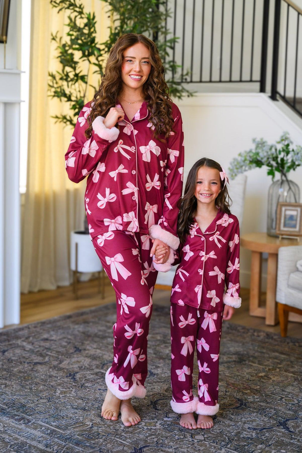 Mom & Me - Fuzzy Pink Bow Pajamas - CHILD-6-12 Months - Matching burgundy fuzzy pajamas with large pink bows, featuring long sleeves and cuffs, worn by mother and daughter.