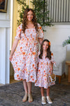 Mom & Me - Floral Fall Watercolor Dress - CHILD-6-12 Months - Cream-colored floral watercolor dresses with orange and pink flowers, puffed sleeves, and smocked bodices, worn by woman and