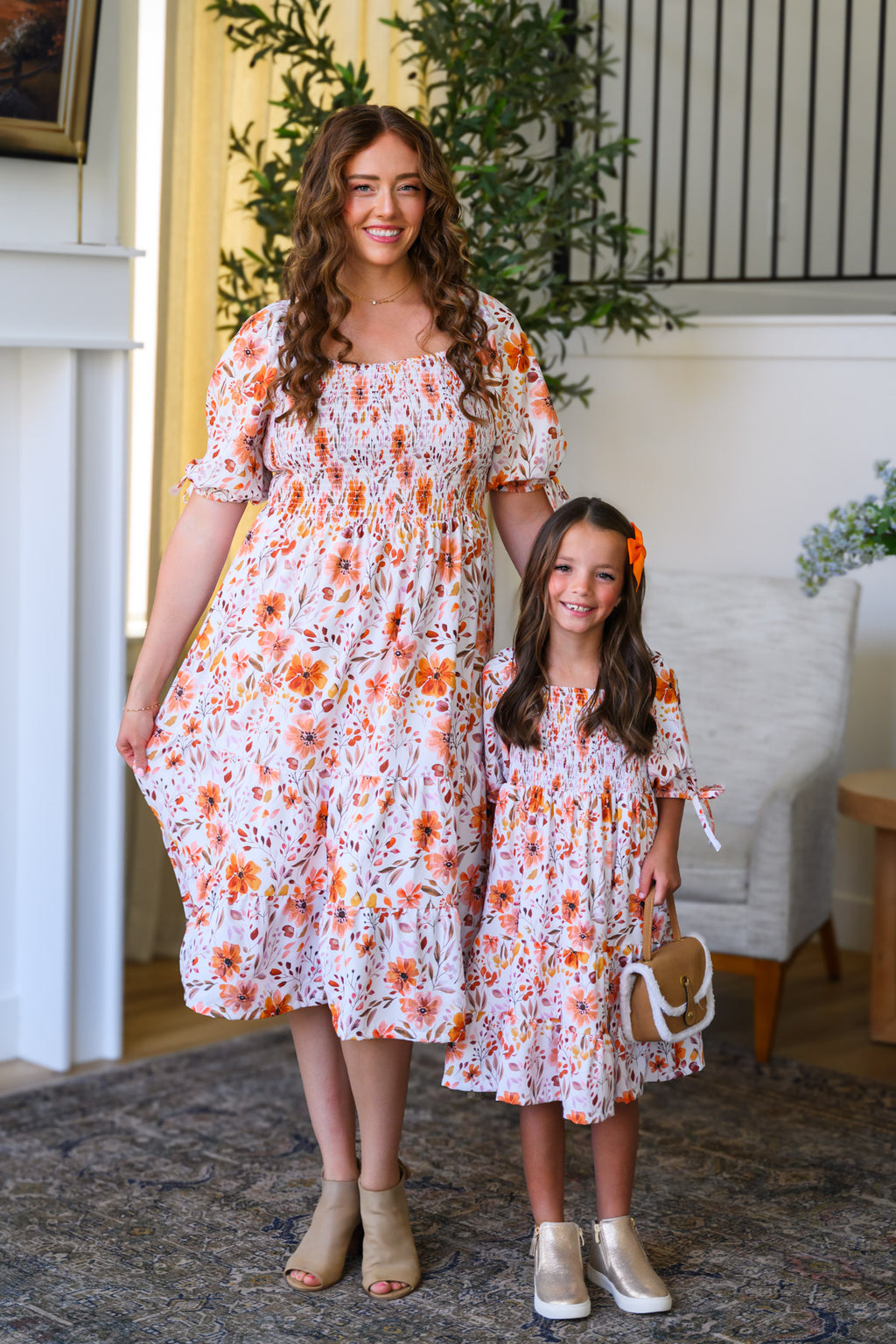 Mom & Me - Floral Fall Watercolor Dress - CHILD-6-12 Months - Cream-colored floral watercolor dresses with orange and pink flowers, puffed sleeves, and smocked bodices, worn by woman and