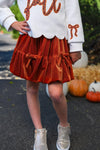 "Fall" Rust Floral Suede Skirt Set - 6-12 Months - Rust-colored suede skirt with tiered ruffles, worn with a white sweater featuring rust floral embroidery and scalloped hem.