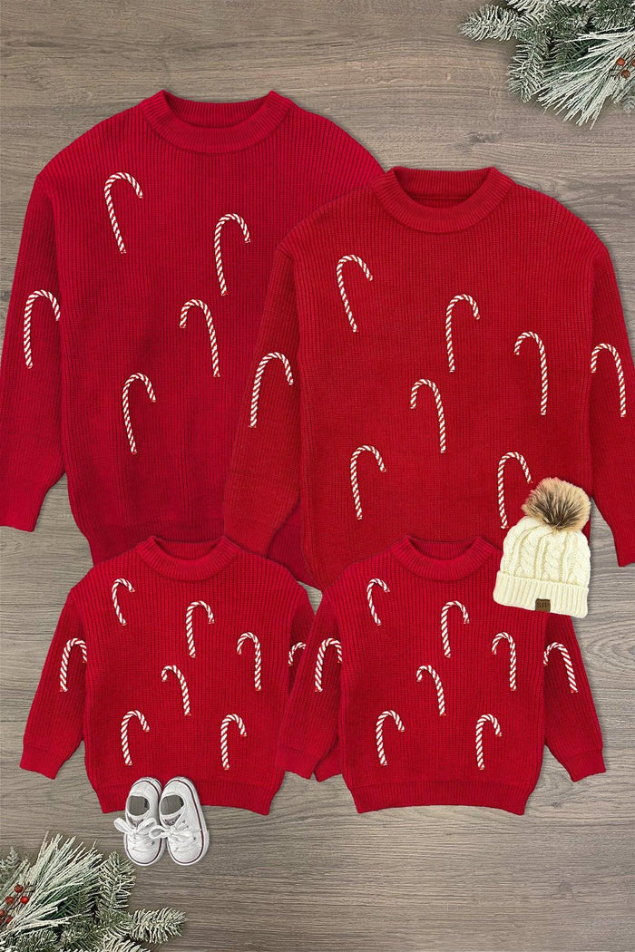 Candy Cane Family Knit Sweater - CHILD-3XS-6-12 Months-FAMILY - Red knit sweaters with scattered white candy cane patterns in various child and adult sizes displayed on a wooden surface.