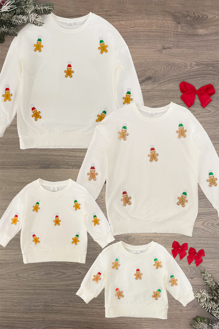 Cream Sequin Gingerbread Man Family Tops - GIRL-3XS-6-12 Months-FAMILY - Cream long-sleeve tops with sequin gingerbread men appliques in various sizes laid flat on wood background.