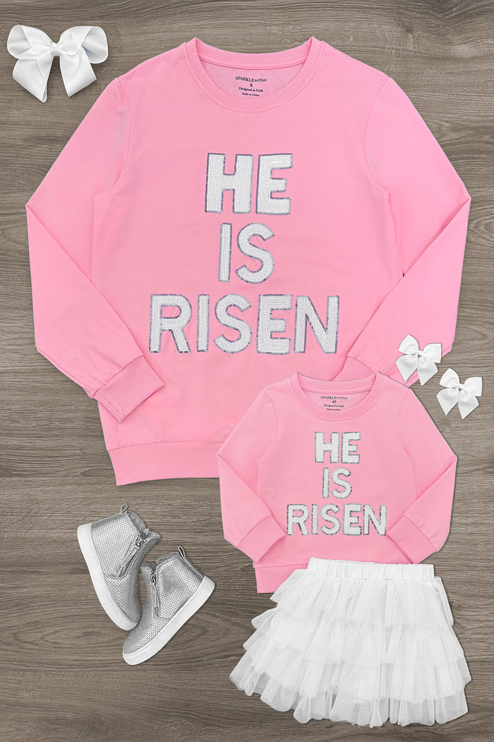 Mom & Me - "He Is Risen" Top & Skirt Set - CHILD-6-12 Months - Pink long-sleeve top with white "He Is Risen" lettering, paired with white ruffled skirt and matching hair bows and silver.