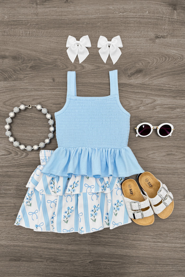 Blue Floral Bows Skirt Set - 6-12 Months - Blue sleeveless dress with floral and stripe skirt, paired with white sandals, white bow clips, round sunglasses, and a.
