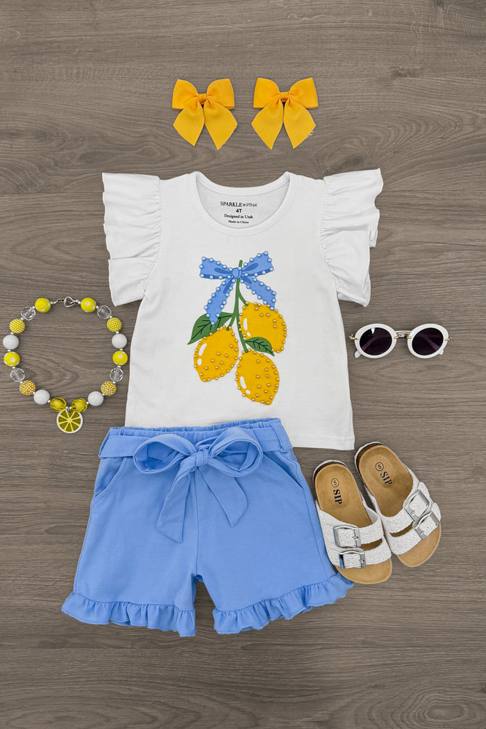 Blue Lemon Short Set - 6-12 Months - White ruffled sleeve top with blue bow and lemon print, paired with blue ruffled shorts, yellow hair bows, white sandals,.