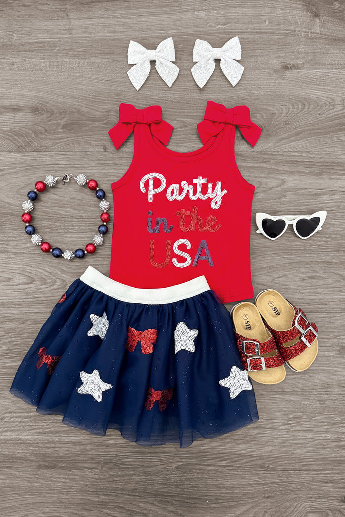 "Party In The USA" Skirt Set - 6-12 Months - Red sleeveless top with "Party in the USA" text paired with navy blue tulle skirt featuring white and red stars, white bow.