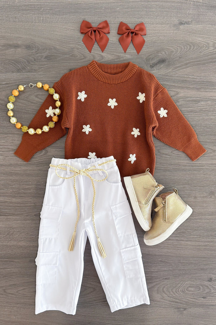 Brown Flower Sweater Cargo Pant Set - 3XS-6-12 Months - Brown knit sweater with white flower details, white cargo pants, beige boots, two brown hair bows, and a beaded bracelet on.