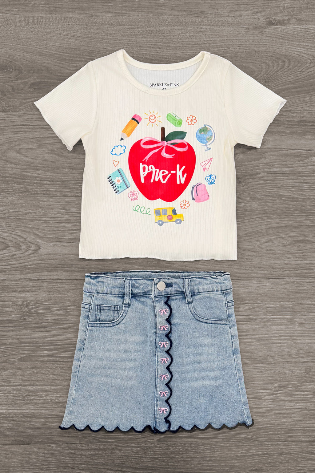 "Pre-K - Fifth Grade" Apple Denim Skirt Set - PRE-K / 2T - Cream short-sleeve tee with red apple graphic and light blue scalloped denim skirt with pink buttons.