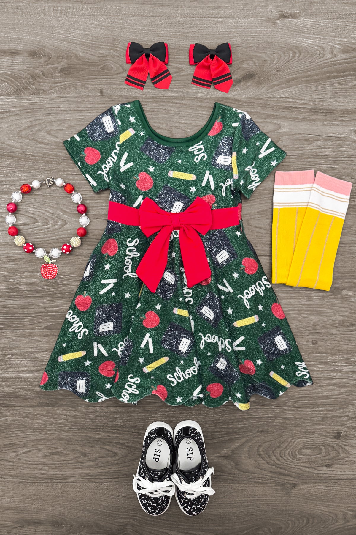 Green Glitter School Supplies Dress - 3T - Green short-sleeve dress with school supplies print, red bow waist, and matching red bows with black trim on hair clips.