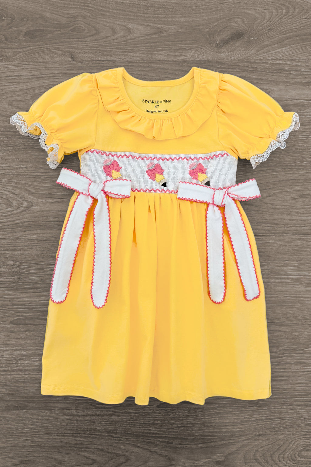 Yellow Pencil & Bows Dress - 3T - Yellow short-sleeve dress with scalloped white lace trim, smocked bodice featuring pink bows, and matching fabric belt with.