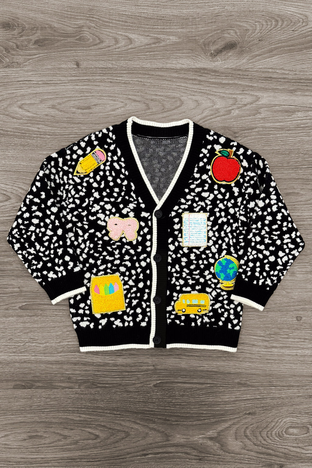Mom & Me - Composition Sweater Cardigan - CHILD-3T - Black cardigan sweater with white speckles, colorful cartoon patches, and white trim on collar and cuffs.