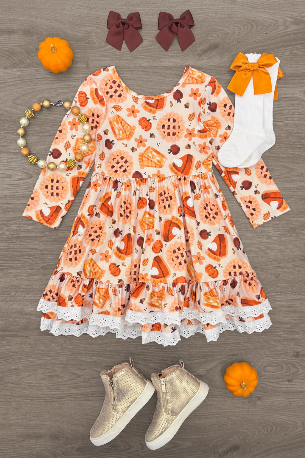 Autumn Pie Ruffle Dress - 6-12 Months - Orange long-sleeve dress with autumn-themed prints, ruffled sleeves, and white lace trim at hem.