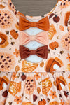 Autumn Pie Ruffle Dress - 6-12 Months - Orange dress with autumn pie and pumpkin print, featuring three stacked fabric bows in rusty orange, peach, and brown on the