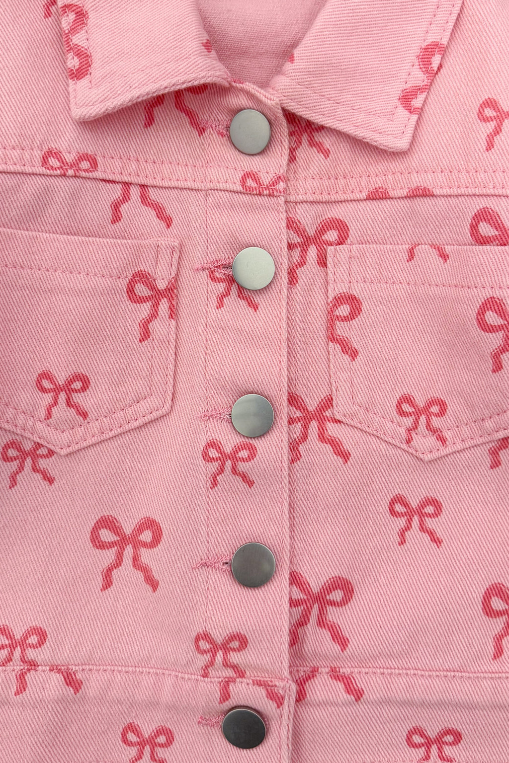 Pink Bow Denim Jacket - 6-12 Months - Pink denim jacket with all-over small bow print, snap buttons, and front chest pockets.