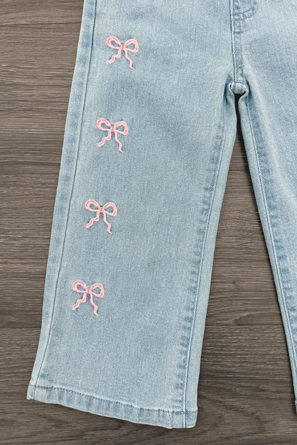 Pink Denim Bow Pants - 6-12 Months - Light blue denim pants with wide legs and four small pink embroidered bows on the left leg.
