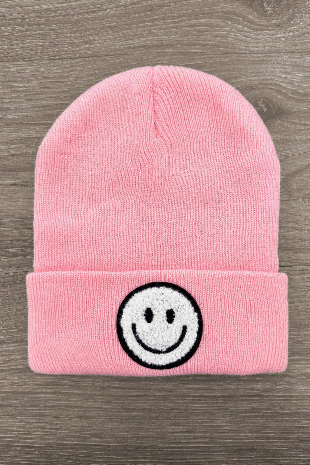 Smiley Face Beanies - Pink - Pink knitted beanie hat with folded cuff and black-and-white embroidered smiley face on front.
