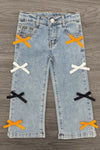 "Spooky Season" Bow Denim Pant Set - 6-12 Months - Light blue denim pants with decorative orange, white, and black bow accents on front legs.