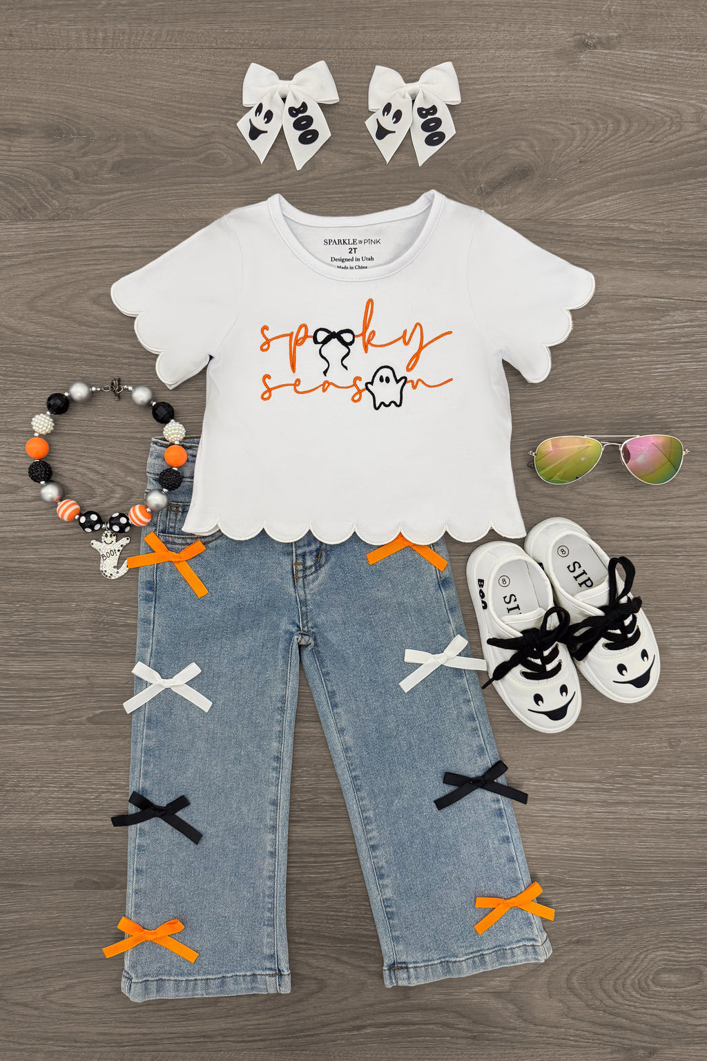 "Spooky Season" Bow Denim Pant Set - 6-12 Months - White scalloped-edge short sleeve top with "spooky season" orange and black text, light blue denim pants decorated with.