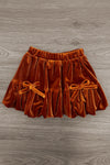 "Fall" Rust Floral Suede Skirt Set - 6-12 Months - Rust-orange suede skirt with elastic waistband and two small decorative bows on front pleated panels.