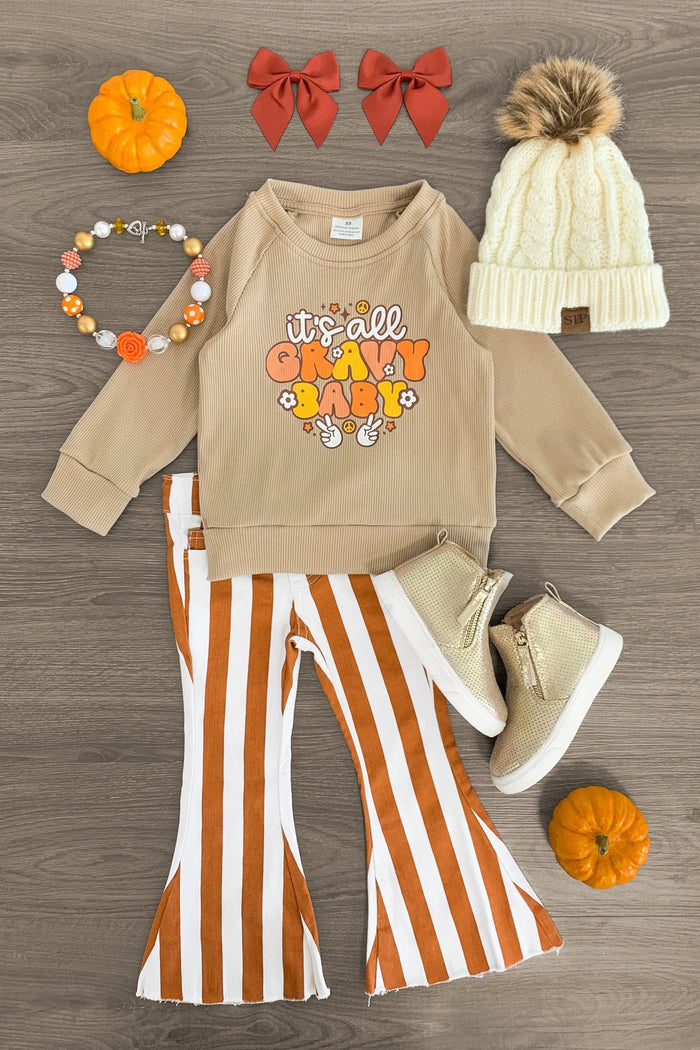 "It's All Gravy Baby" Striped Denim Bell Bottom Set - 3XS-6-12 Months - Beige long-sleeve top with colorful "It's All Gravy Baby" text, brown and white striped bell-bottom pants, cream knit hat.