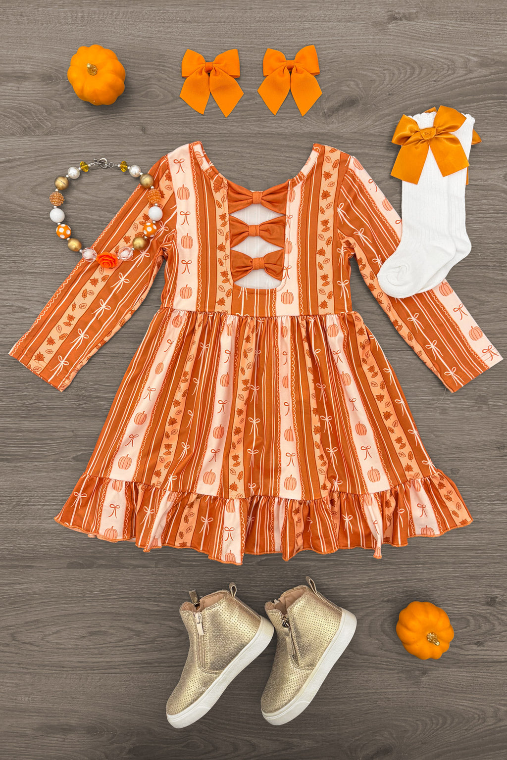 Pumpkins & Bows Stripe Dress - 6-12 Months - Orange and white striped long-sleeve dress with ruffled hem and pumpkin patterns, paired with bow hair clips, beaded.