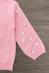 Pink & Brown Floral Skirt Set - 6-12 Months - Pink knit sweater sleeve with small white and yellow floral appliques arranged in a scattered pattern.