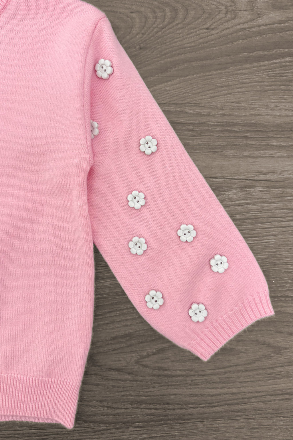 Pink & Brown Floral Skirt Set - 6-12 Months - Pink knit sweater sleeve with small white and yellow floral appliques arranged in a scattered pattern.