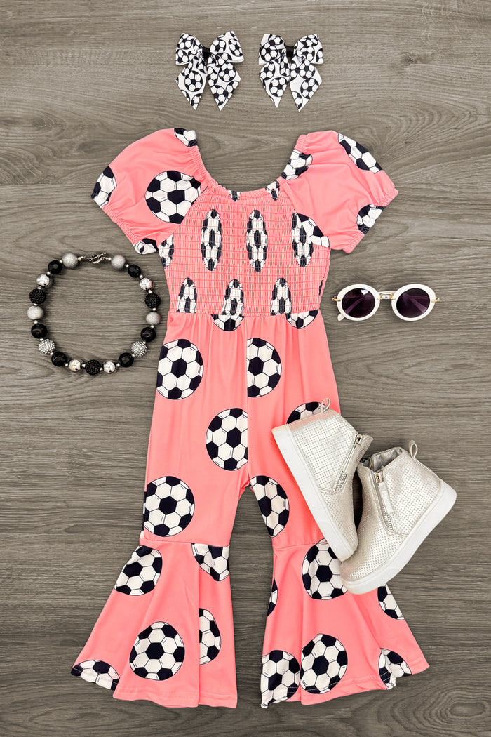Pink Soccer Ball Jumpsuit - 3XS-6-12 Months - Pink jumpsuit with black and white soccer ball print, ruffled hem, and puff sleeves with matching bow headbands and white.