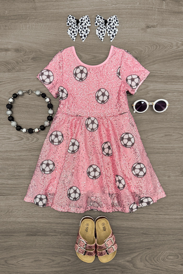 Pink Sequin Soccer Dress - 3XS-6-12 Months - Pink sequin dress with soccer ball print, ruffled sleeves, paired with spotted hair bows, black bead bracelet, white.