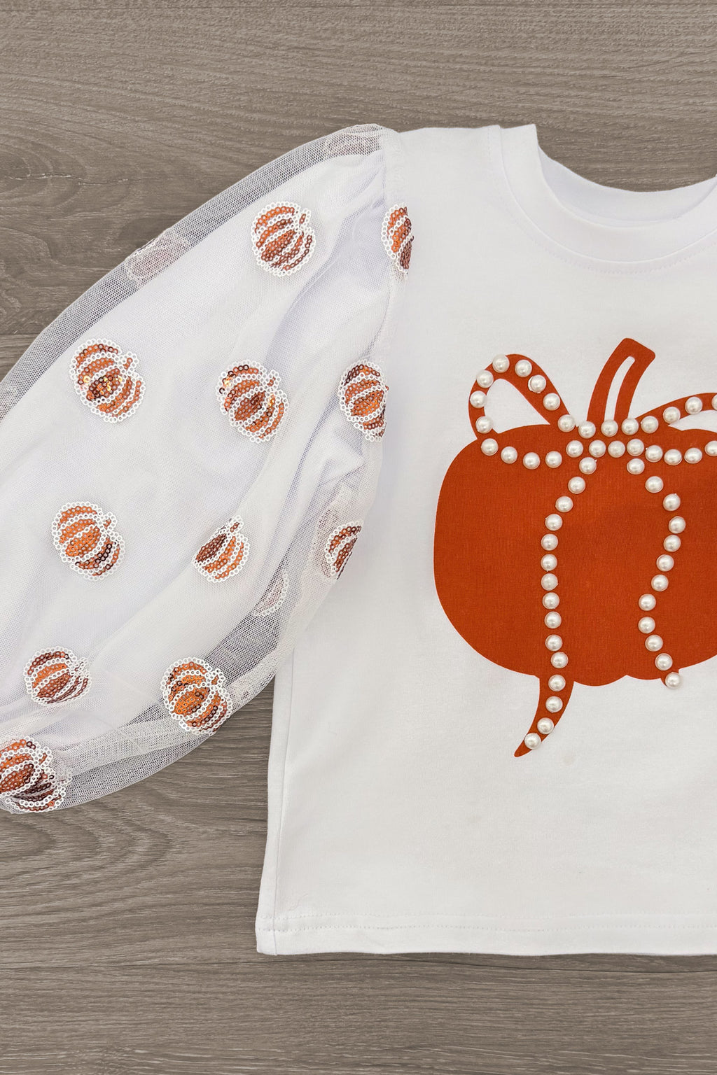 Pearl & Sequin Rust Pumpkin Skirt Set - 6-12 Months - White long-sleeve top with sheer puff sleeves adorned with rust-colored sequin pumpkins and a large rust pumpkin on the.