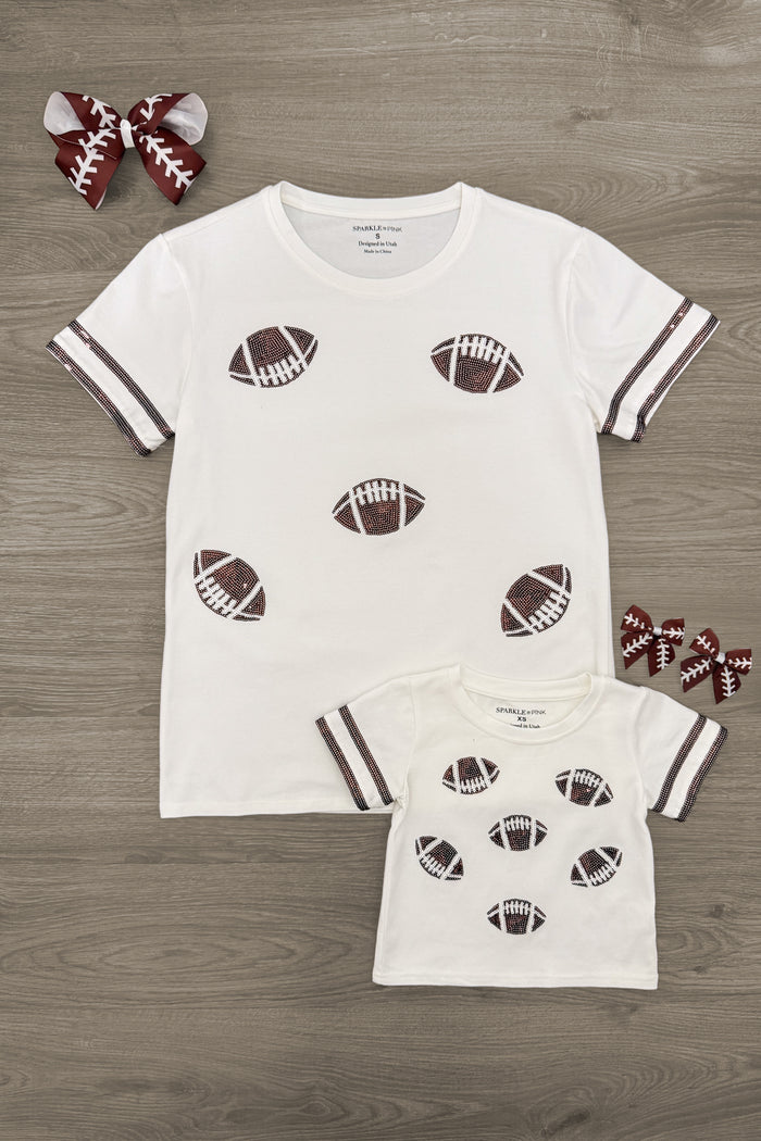 Mom & Me - Sequin Football Top - CHILD-3XS-6-12 Months - White short-sleeve tops with brown football prints and striped cuffs, adult and child sizes displayed with matching hair bows.