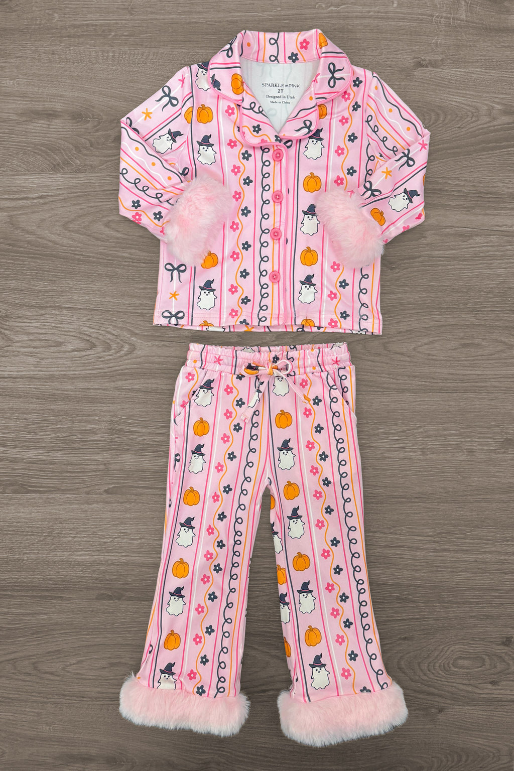 Mom & Me - Fuzzy Pumpkin & Ghost Pajamas - CHILD-6-12 Months - Pink long-sleeve button-up pajamas with Halloween-themed pumpkin, ghost, and candy prints, featuring white fuzzy cuffs on.