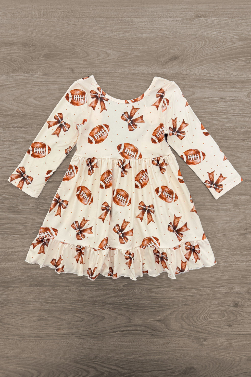 Football Bow Dress - 6-12 Months - Cream long-sleeve toddler dress with football print and ruffled hem.