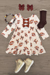 Football Bow Dress - 6-12 Months - Cream long-sleeve dress with brown football print and lace-up front, paired with brown knee-high socks, maroon hair bows,.