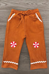 Gingerbread Man Costume - 6-12 Months - Brown soft fabric pants with white zigzag trim and red-and-white peppermint candy patches on knees.