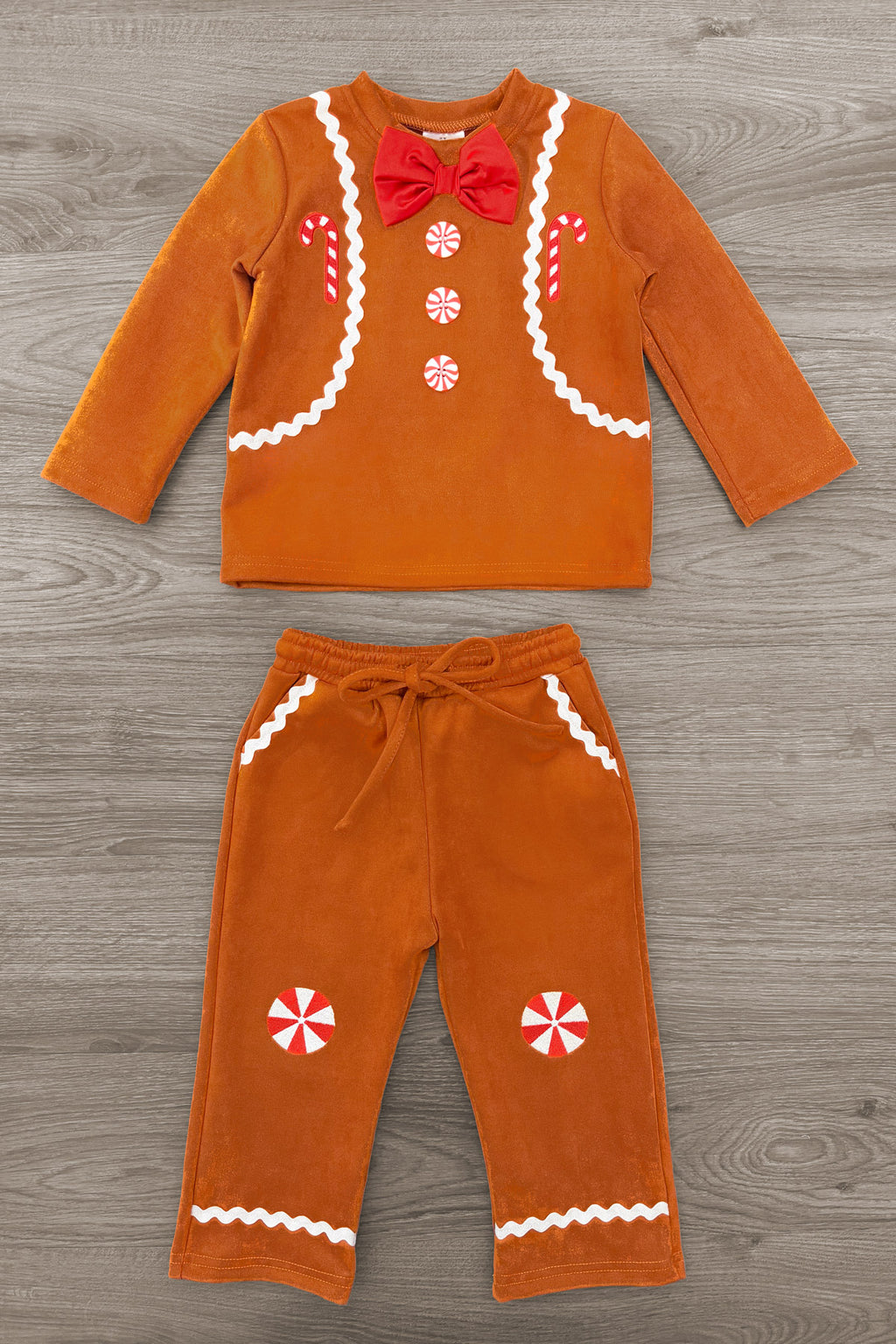 Gingerbread Man Costume - 6-12 Months - Orange long-sleeve top and pants set with gingerbread man design, white icing trim, red bow tie, and peppermint candy.