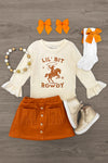 "Lil' Bit Rowdy" Suede Skirt Set - 6-12 Months - Cream long-sleeve bodysuit with "Lil' Bit Rowdy" and horse graphic, rust suede button-front skirt, cream socks with orange.