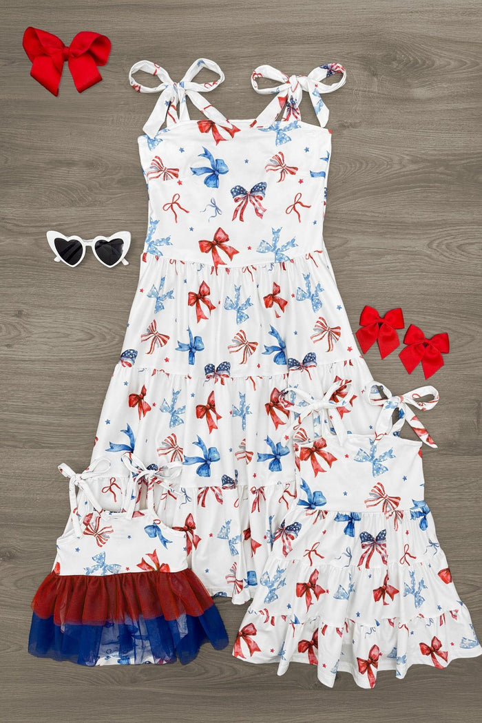 Mom & Me - Red White & Blue Bow Dress - BABY-NEWBORN-FAMILY - White sleeveless bow dress with red, white, and blue ribbon print, paired with matching smaller dress and red bow accessories.