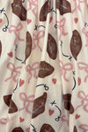 "Game Day" Football Bow Dress - 6-12 Months - Cream fabric dress with brown footballs and pink ribbons, playful sports-themed pattern.