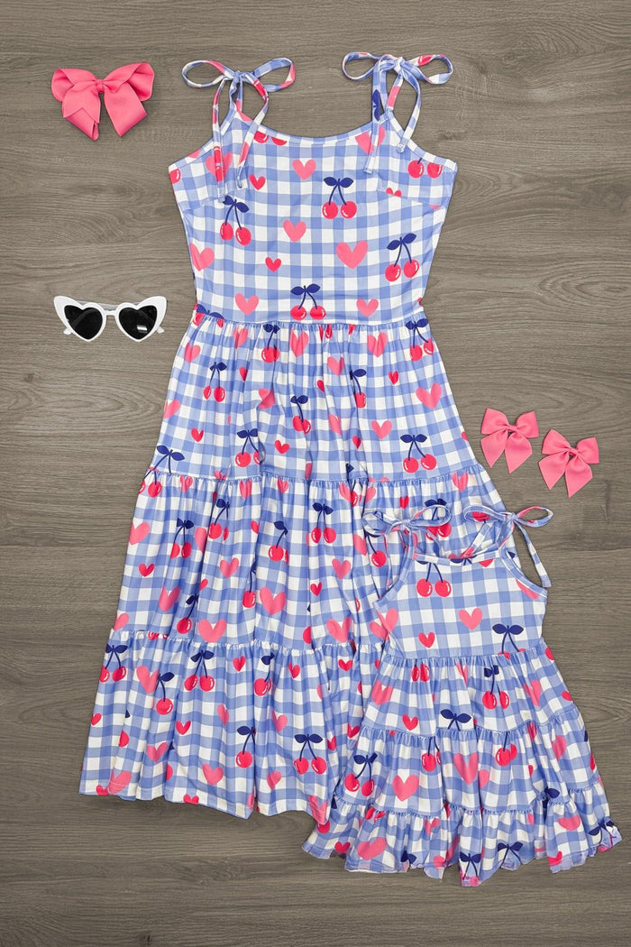 Mom & Me - Gingham Cherry Heart Dress - CHILD-3XS-6-12 Months - Blue gingham dress with red heart and cherry print, spaghetti ties, tiered skirt, paired with two pink bows and white heart.