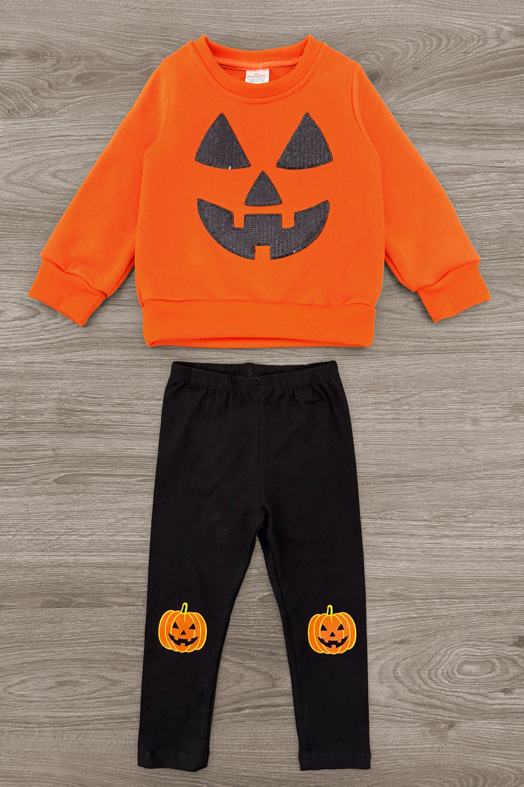 Jack O' Lantern Legging Set - 6-12 Months - Orange long-sleeve sweatshirt with a black jack-o'-lantern face and black leggings featuring small pumpkin prints on the.