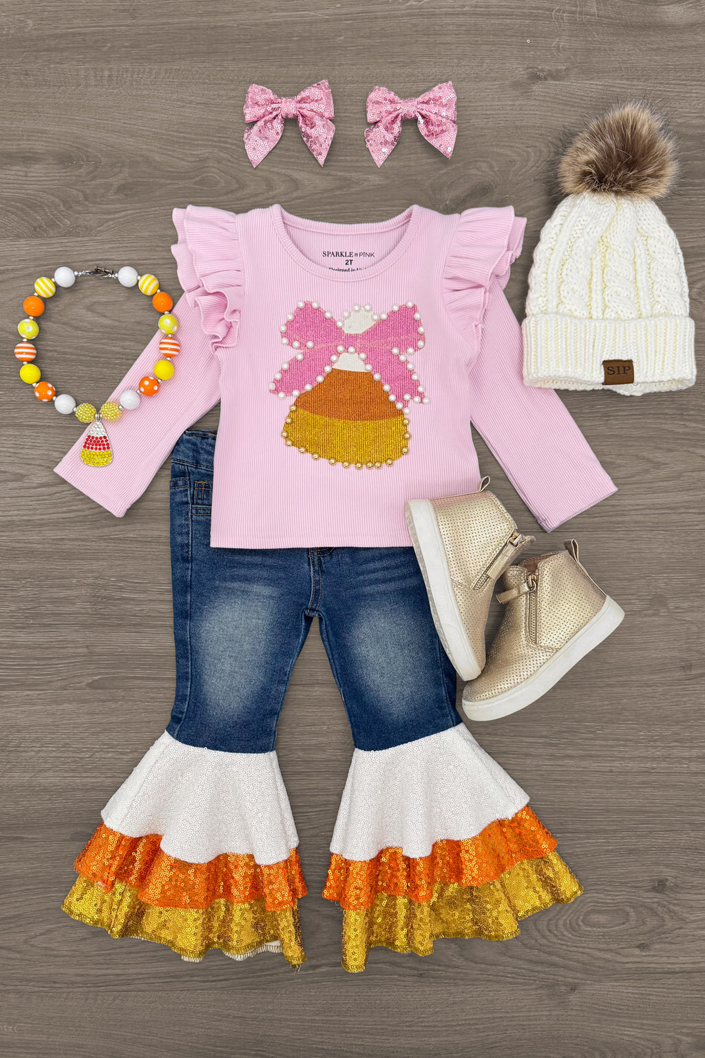 Candy Corn Bow Denim Bell Bottom Set - 6-12 Months - Pink long-sleeve top with a candy corn graphic paired with denim bell-bottom pants featuring orange and white tiered ruffle.