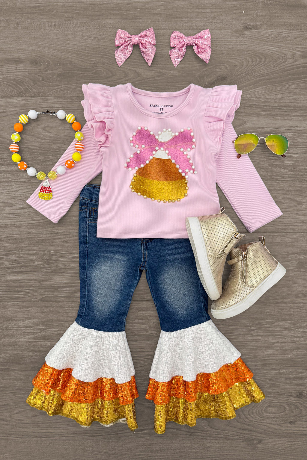 Candy Corn Bow Denim Bell Bottom Set - 6-12 Months - Pink long-sleeve top with candy corn graphic and ruffled shoulders, paired with blue denim bell bottoms featuring layered.