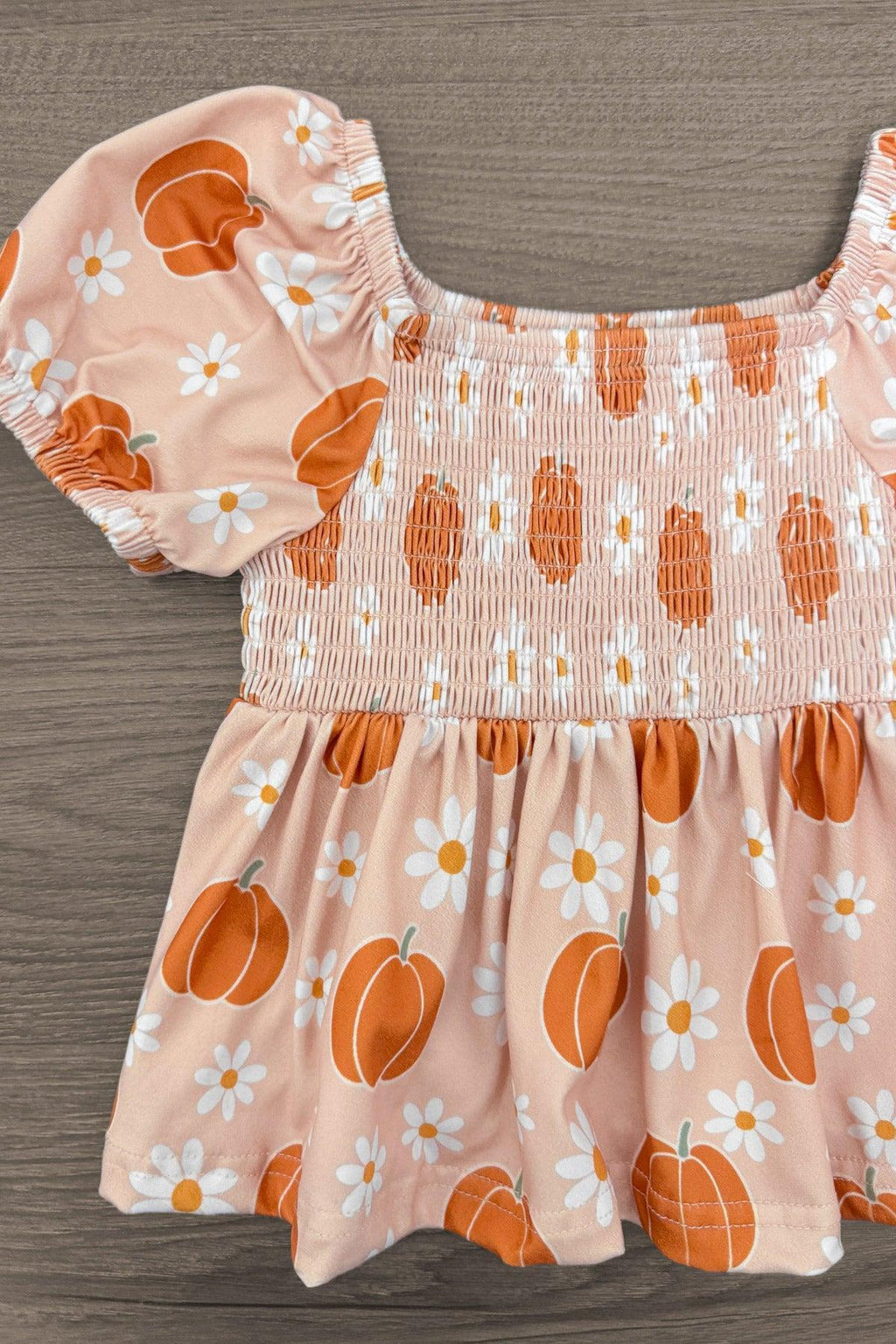 Pumpkin Daisy Denim Bell Bottom Set - 6-12 Months - Pale pink floral baby dress with puff sleeves, smocked bodice, and orange pumpkin print.