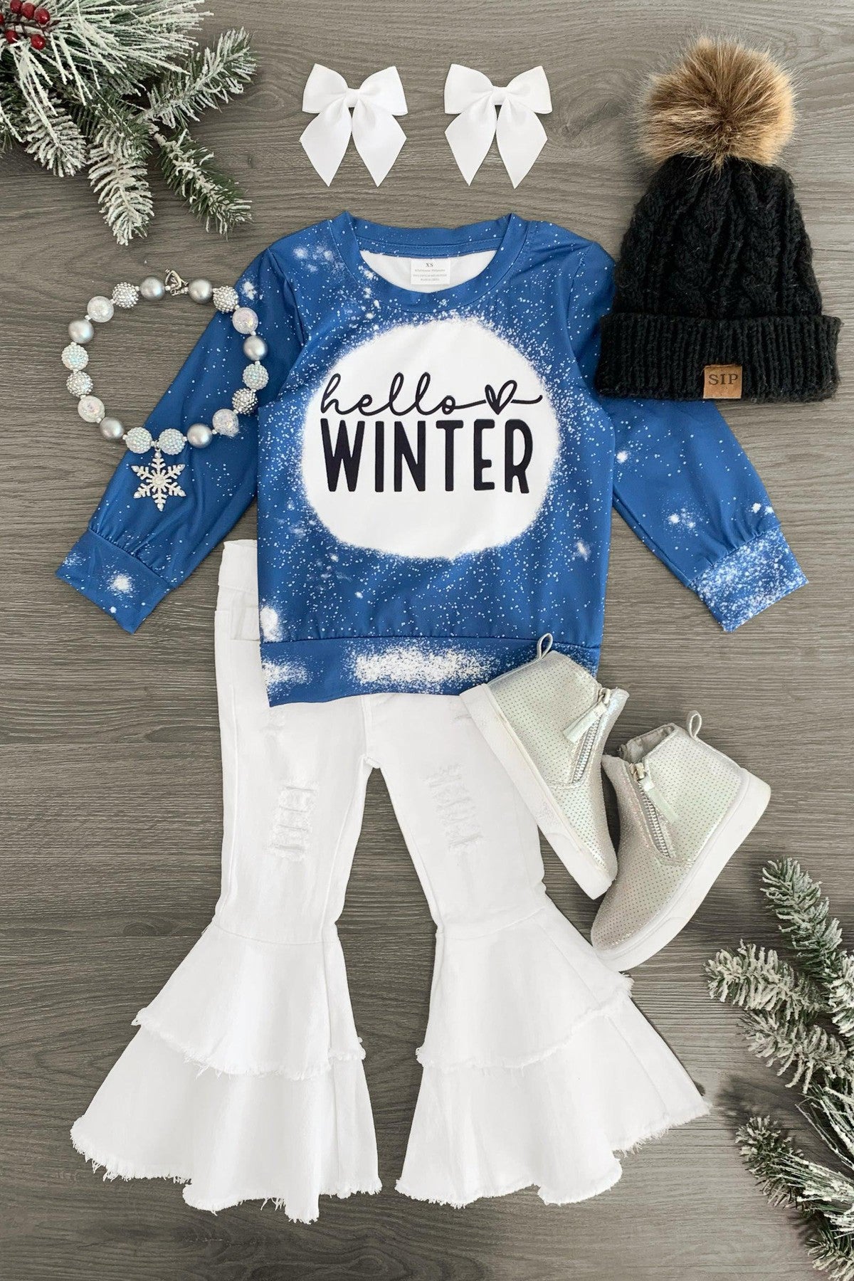 "Hello Winter" Denim Bell Bottom Set - 3XS-6-12 Months - Blue denim long-sleeve shirt with "hello winter" text, white bell-bottom pants, white boots, black knit hat with pom-pom,.