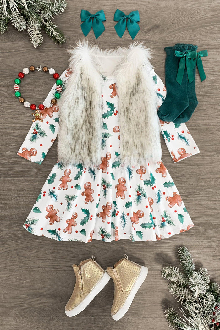 White Holly Gingerbread Dress - 3XS-6-12 Months - White dress with gingerbread man and holly print, faux fur vest, green velvet bow clips, green socks, bead necklace, and tan .