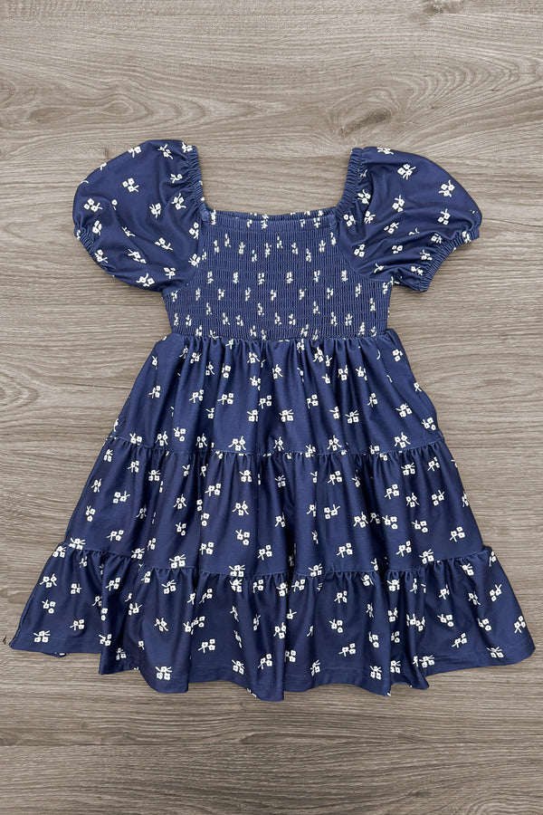 Mom & Me - Navy Floral Dress - CHILD-6-12 Months - Navy blue floral dress with puff sleeves, a smocked bodice, and a gathered skirt.