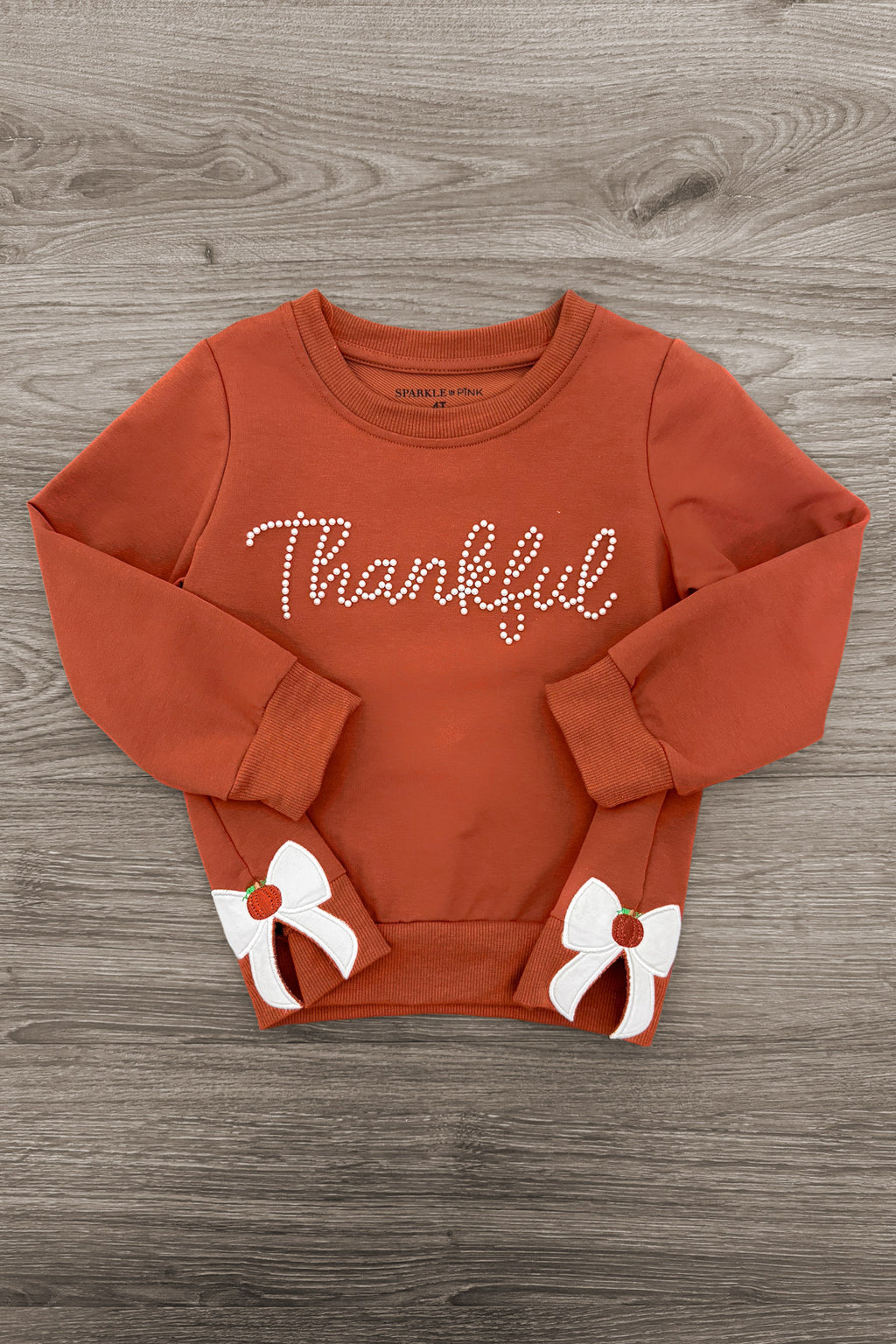 Mom & Me - "Thankful" Bow Pullover - CHILD-6-12 Months - Rust-orange pullover with "Thankful" script and white bow accents on cuffs.